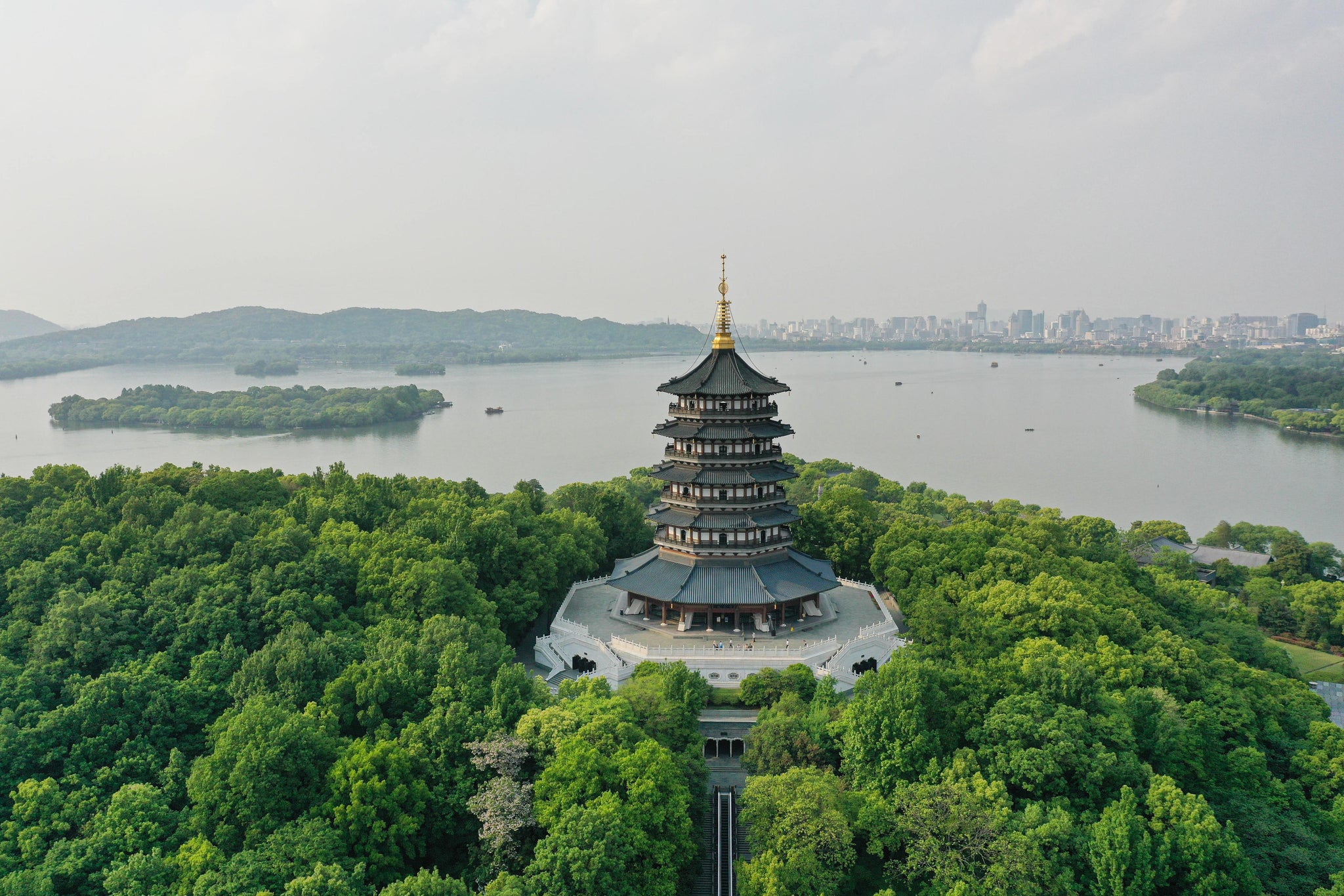 Aerial view of a pagoda surrounded by lush greenery near a lake, showcasing China's rich cultural heritage on a 30-Day Tour.